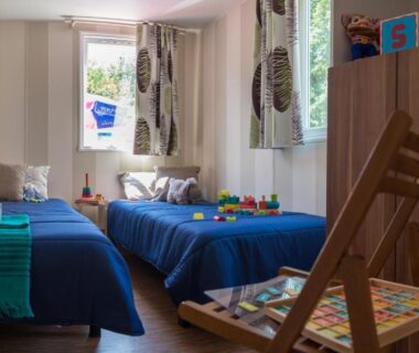 Chambre avec deux lits jumeaux et jouets au Camping Officiel Siblu Domaine de Soulac