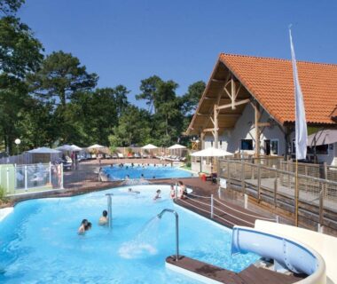 Piscine extérieure avec toboggan et terrasse au Camping Officiel Siblu Domaine de Soulac