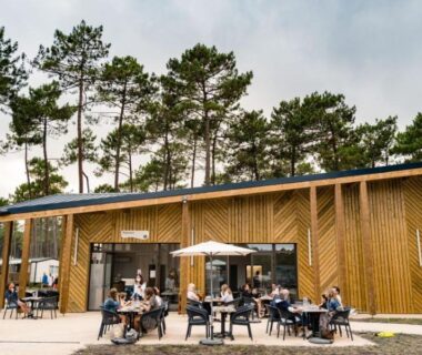 Terrasse extérieure avec tables et parasols au Camping Officiel Siblu Les Dunes de Contis
