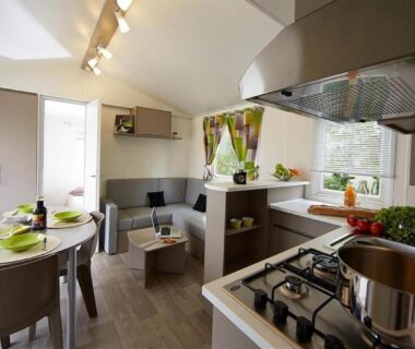 Intérieur mobil-home avec kitchenette et coin repas au Camping Officiel Siblu le Montourey