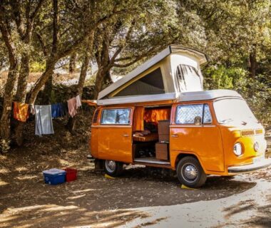 Emplacement ombragé avec van aménagé et linge étendu au Camping Olva Maeva