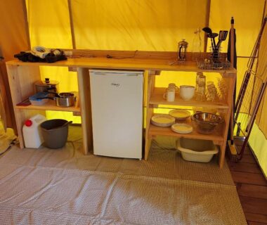 Intérieur de tente avec kitchenette et frigo dans le Camping Onlycamp Le Petit Bocage