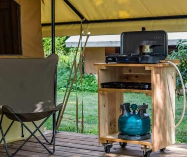 Terrasse en bois avec réchaud gaz et chaise de camping au Camping Onlycamp Le Petit Bocage