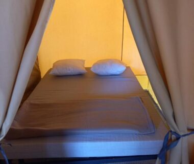 Intérieur de tente avec lit double au camping Onlycamp Le Petit Bocage
