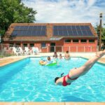 Piscine extérieure avec plongeon et baigneurs au camping Onlycamp Le Pont Romain