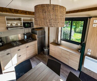 Intérieur du mobil home avec kitchenette et coin repas au Camping Onlycamp Le Pont Romain