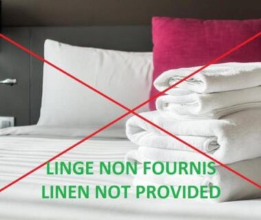 Chambre avec lit serviettes pliées et coussins dans le camping Onlycamp Le Pont Romain
