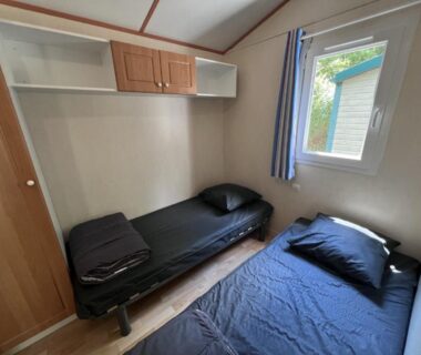 Intérieur chambre avec deux lits simples du Camping Onlycamp Le Pré