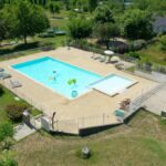 Piscine extérieure et solarium dans le Camping Onlycamp Les Tuillères