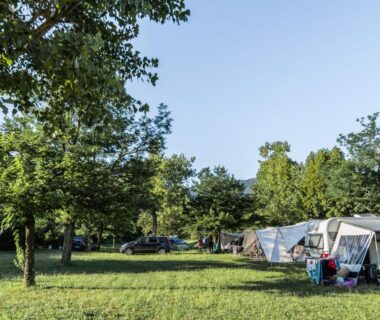 Prairie ombragée avec caravanes et auvents au Camping Onlycamp Les Tuillères
