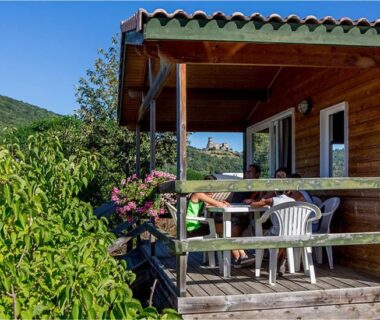Terrasse couverte avec table et chaises au Camping Onlycamp Pierre & Sources