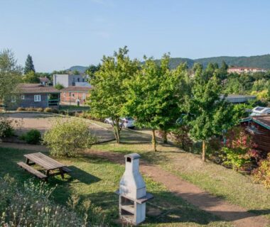 Espace vert avec barbecue et bancs au Camping Onlycamp Pierre et Sources