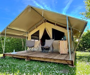 Terrasse de tente lodge avec chaises au Camping Onlycamp Pierre & Sources