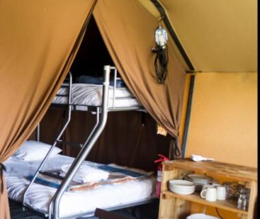 Intérieur de tente avec lits superposés et kitchenette dans le Camping Onlycamp du Rouergue