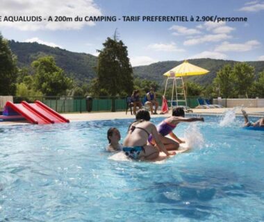 Piscine extérieure avec toboggan et baigneurs au Camping Onlycamp du Rouergue