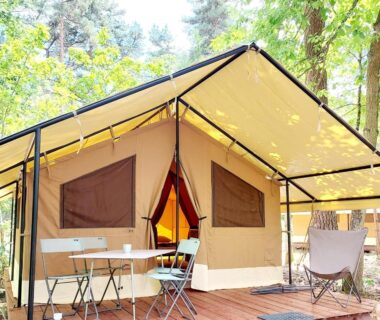 Terrasse en bois avec tente safari et mobilier extérieur au Camping Onlycamp du Rouergue