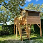 Cabane sur pilotis dans un emplacement ombragé au Camping Onlycamp la Rochette