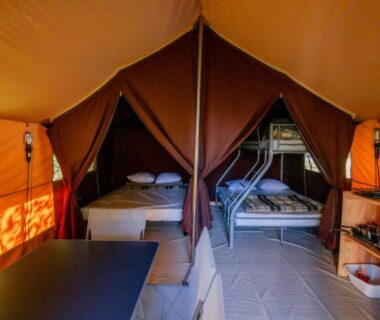Intérieur de tente avec deux lits et kitchenette au Camping Onlycamp la Rochette