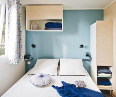 Chambre double lumineuse avec lit et rangements dans un mobil-home du Camping Padimadour