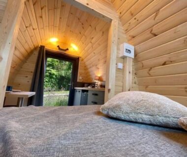 Intérieur de cabane en bois avec lit et kitchenette du Camping Padimadour
