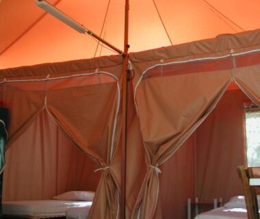 Intérieur de tente avec lits et plancher en bois au Camping Paduella
