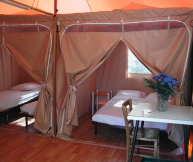 Intérieur de tente avec lits et table dans le Camping Paduella