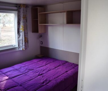 Chambre avec lit double et étagères dans le mobil-home du Camping Paradella