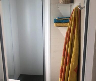 Salle d'eau avec douche et serviettes dans l'hébergement du Camping Paradis Le Grand' R