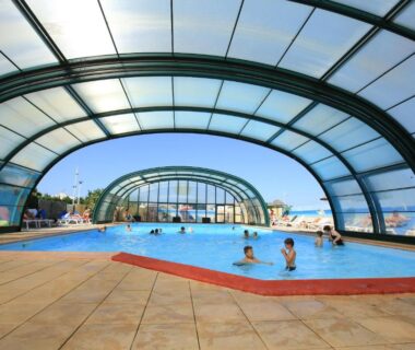 Piscine couverte sous dôme avec baigneurs au Camping Paradis Le Grand' R