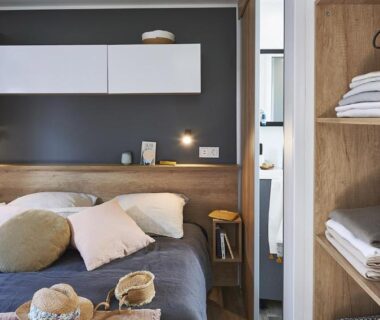 Intérieur de chambre avec lit double et rangement du Camping Paradis Le Grand R