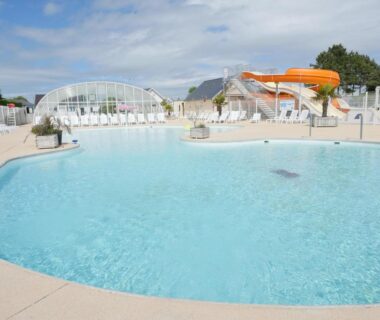 Piscine extérieure avec toboggan et transats au Camping Paradis Le Royon