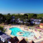 Piscine extérieure avec transats entourée d'hébergements au Camping Paradis Les Galets de la Molliere