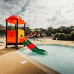 Piscine avec toboggan et transats au Camping Paradis du Quinquis