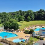 Piscines extérieures avec transats et pelouse au Camping Paradis du Quinquis