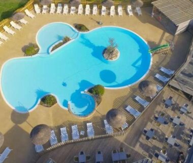 Piscine extérieure avec transats et terrasses du Camping Paradis du Quinquis