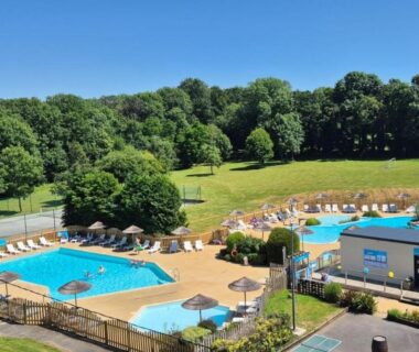 Piscines extérieures avec transats et pelouse au Camping Paradis du Quinquis