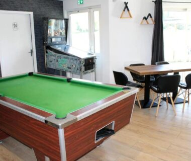 Salle de loisirs avec billard et tables et chaises au Camping Paradis du Quinquis