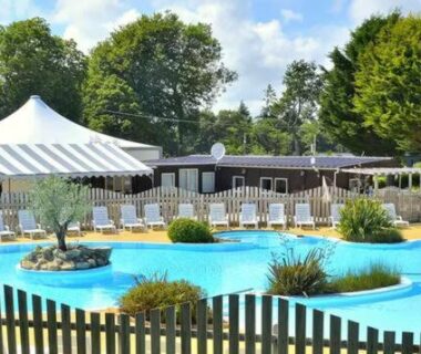 Piscine extérieure avec bassins parasols et transats au Camping Paradis du Quinquis