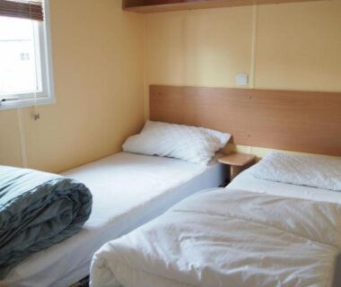 Chambre avec deux lits simples et couettes dans le Camping Paradis du Quinquis