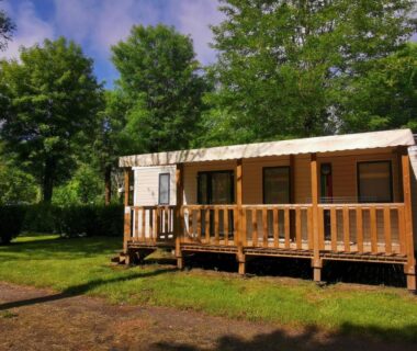 Mobil home avec terrasse sous les arbres au Camping Paradis le Rocher de la Granelle