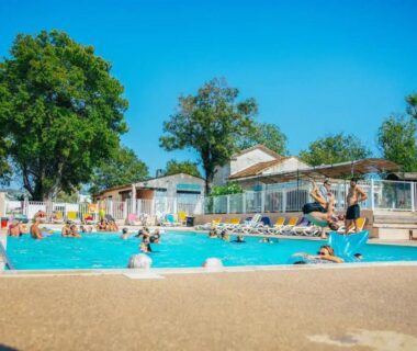 Piscine extérieure avec baigneurs et transats au Camping Parc Bellevue Maeva