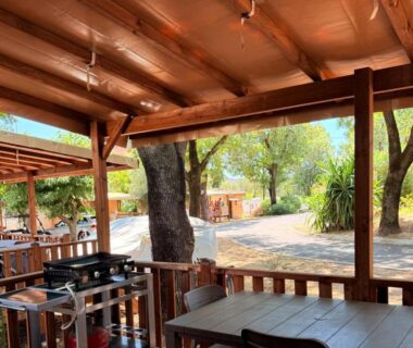 Terrasse couverte avec barbecue et table au Camping Parc Bellevue Maeva