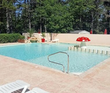 Piscine extérieure avec transats au Camping Parc Saint Sauvayre