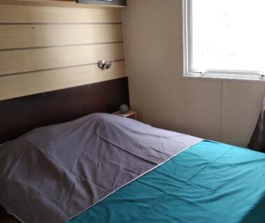 Chambre double avec lit et fenêtre au Camping Parc des 7 Fonts