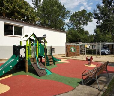 Aire de jeux avec toboggans et bancs au Camping Parc des 7 Fonts