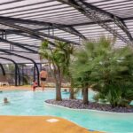 Piscine couverte avec îlot de palmiers au Camping Park Er Lann
