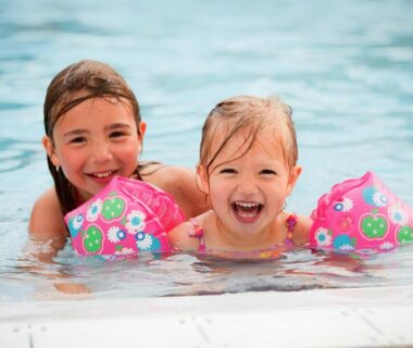 Piscine avec deux enfants souriants dans l'eau au Camping Park Er Lann