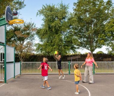 Terrain de basket extérieur avec enfants jouant au ballon au Camping Park Er Lann