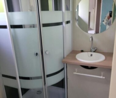 Salle de bain avec cabine de douche et lavabo du Camping Pezza Cardo