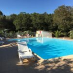 Piscine extérieure avec chaises longues au Camping Pezza Cardo